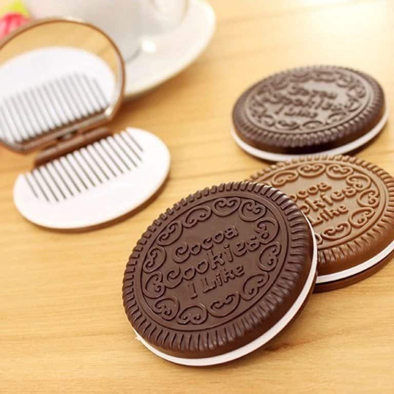 Four cookie-shaped mirror & hair comb sets on a wooden table